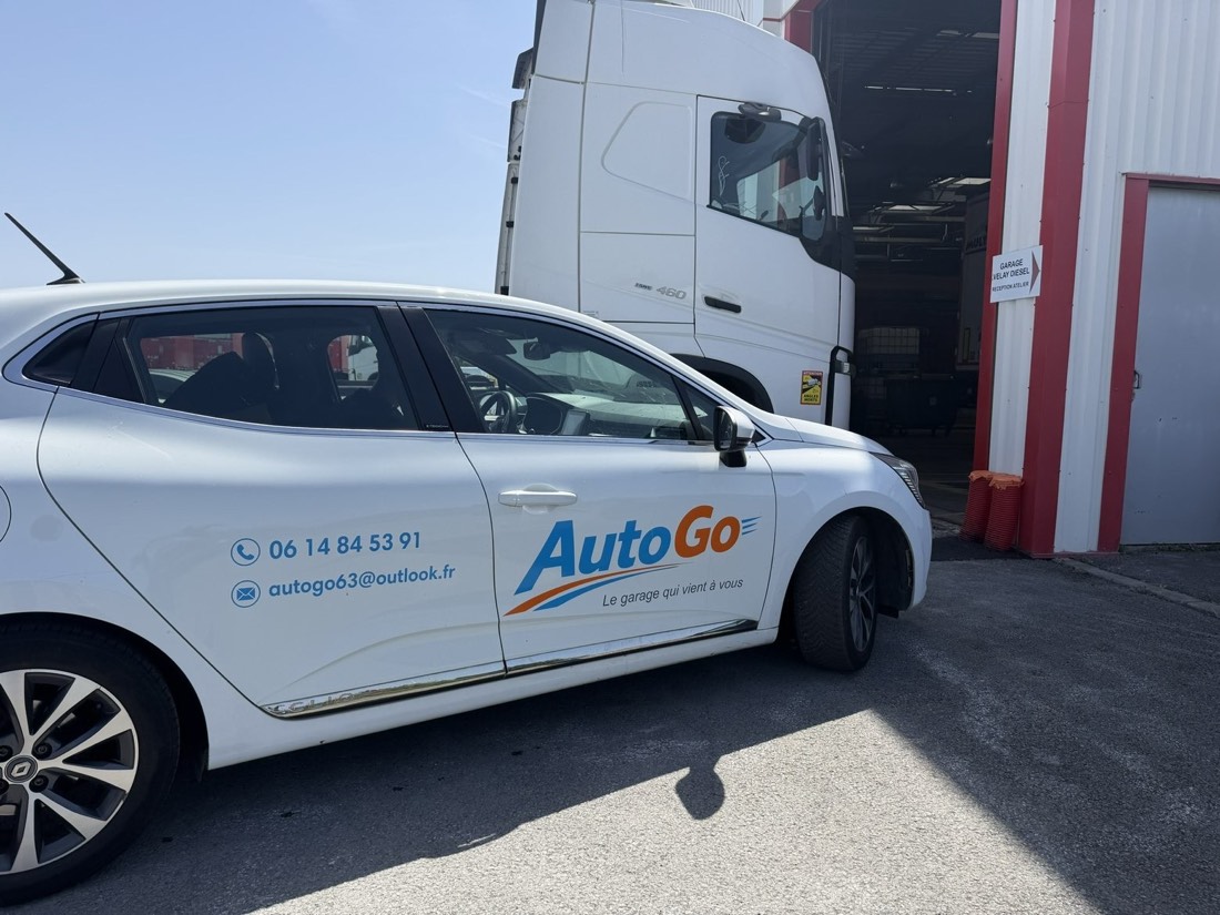 Véhicule floqué AutoGo garé devant un site professionnel